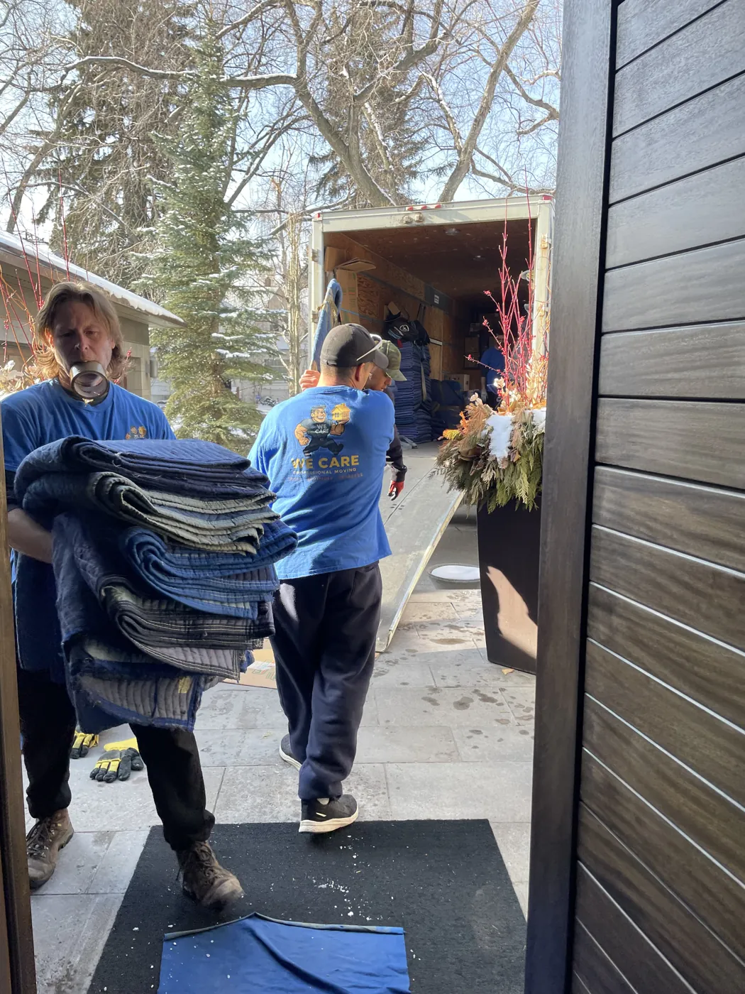 Moving crew carrying protected furniture along the prepared loading route