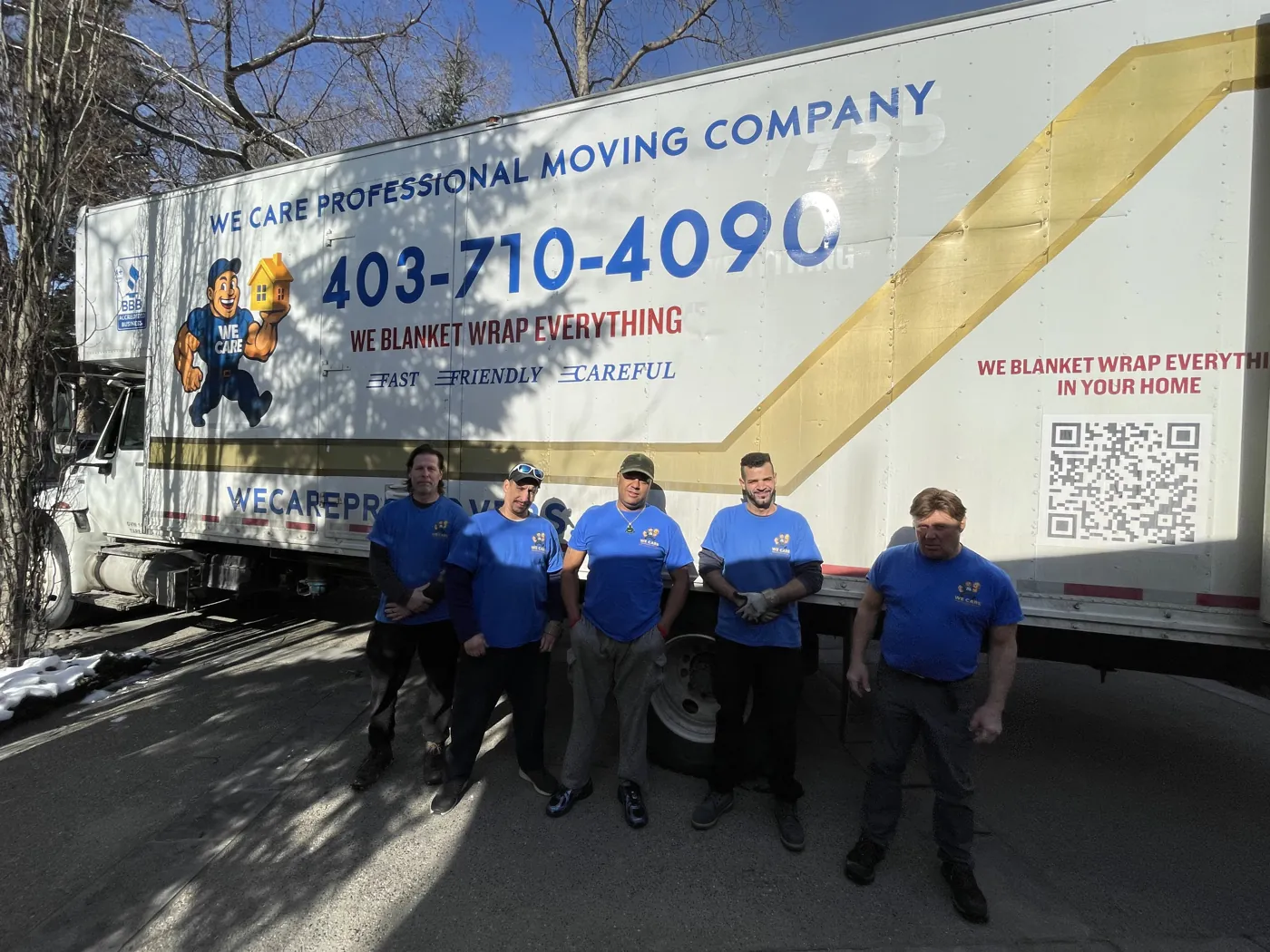 We Care moving crew standing beside the branded company truck