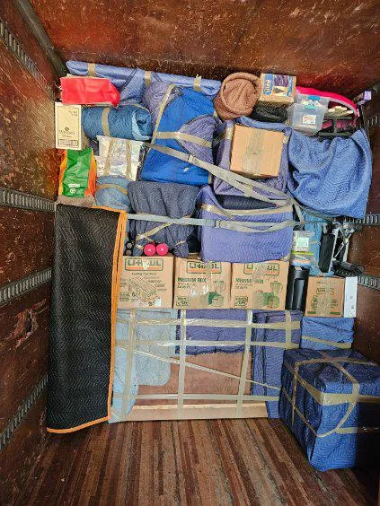 Household belongings and moving equipment organized inside a moving truck
